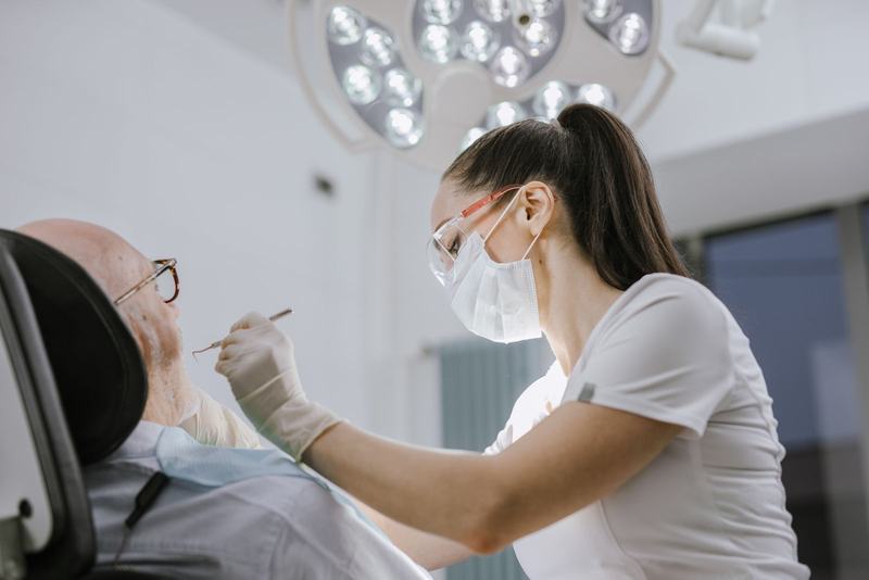 Dentista examinando um paciente idoso em um consultório iluminado